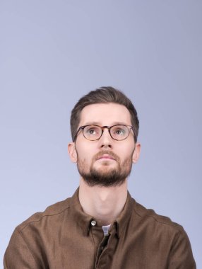 Şık modern adam hakkında bir şey, kafasını yukarı kaldırarak düşünüyor. 