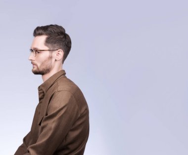 Profilde boş alana sahip bir adamın portresi. Sarkık gözleri olan üzgün genç adam. Şık görünüm, saç modeli ve sakal