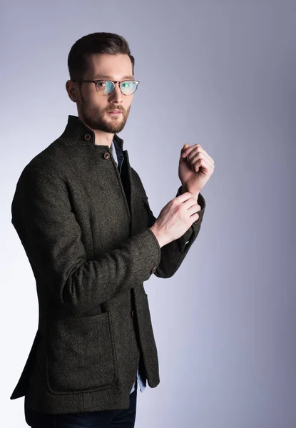 Retrato vertical de un joven guapo con abrigo. Gafas y barba —  Fotos de Stock