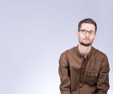 Portre ile özgür yer. Tarafsız bir göz ile tarafına bakarak gözlüklü genç bir adam. Şık görünümü, bıyık ve sakal. Bir şey hakkında düşünmekten ya da bir şey seçme