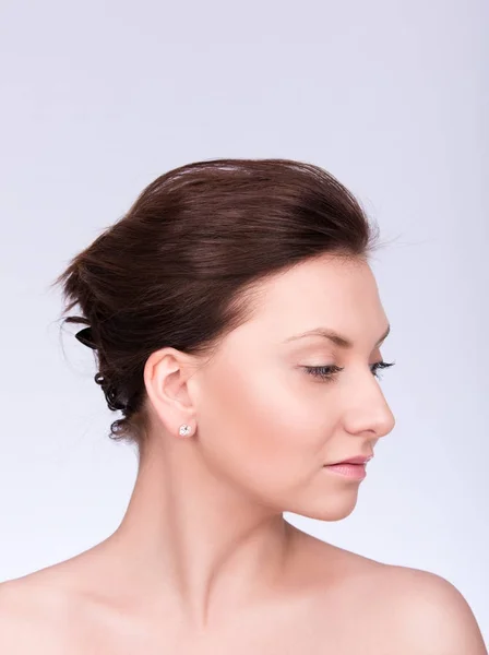 Närbild porträtt av en vacker ung kvinna med insamlade hår och hud. Profil, blicken riktad nedåt — Stockfoto