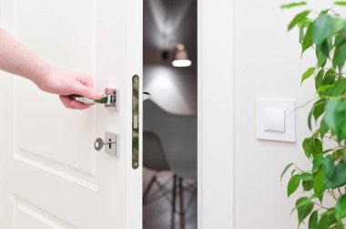 Kapıyı açmak için. Modern beyaz kapı krom metal kolu ve bir adamın kolu ile