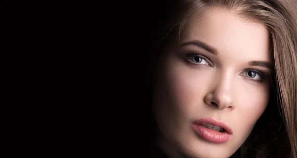Beauty porträtt. Ansiktet av en ung vacker kvinna närbild på svart bakgrund — Stockfoto