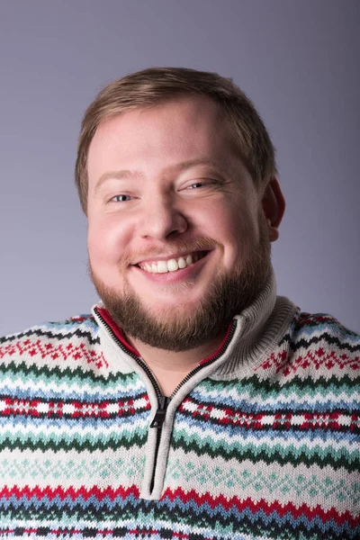 Un jeune homme avec une barbe, portant un pull. Un large sourire — Photo