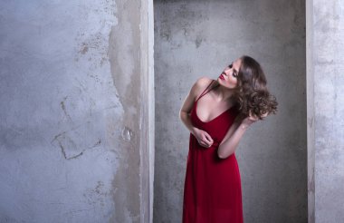 Kırmızı elbiseli genç güzel kadın saçı düzeltiyor