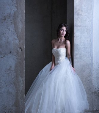 Beyaz gelinlikle beton duvara yanında çıplak omuz ile genç gelin