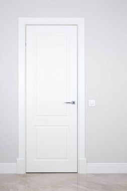 Beyaz kapı ve bir ışık gri duvardaki düğmeye. Öğeleri parlak iç