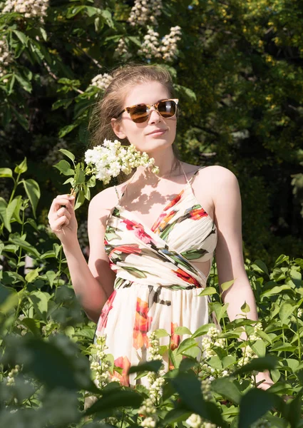 Retrato vertical de uma jovem mulher em óculos de sol e vestido no parque — Fotografia de Stock