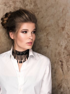 Dikey boynunda siyah bir gerdanlık ile beyaz bir gömlek güzel genç bir kadın portresi