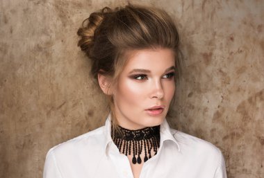 Boynunda siyah bir gerdanlık ile beyaz bir gömlek güzel genç bir kadın portresi