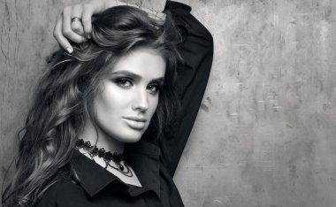 Siyah beyaz portre portre siyah gömlekli bir metal duvarın önünde poz genç güzel kadın