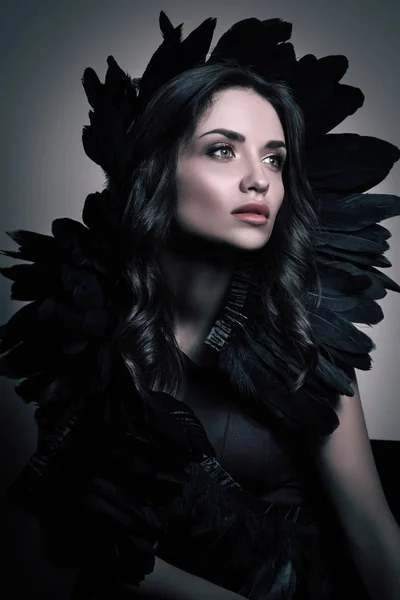 Κάθετη ομορφιά πορτραίτο σε σκούρους τόνους. Πολυτελή νεαρή γυναίκα με τα μαύρα φτερά στα μαλλιά της — Φωτογραφία Αρχείου