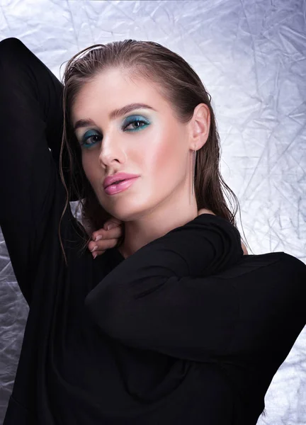 Retrato vertical de una joven sexy en negro. Maquillaje profesional y cabello húmedo — Foto de Stock