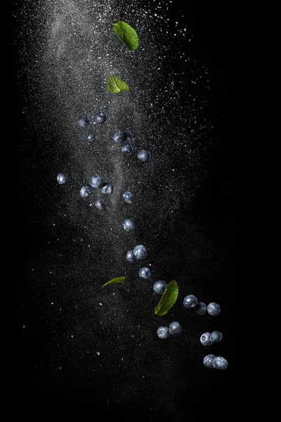 Mirtilli e foglie di menta in volo su sfondo nero — Foto Stock