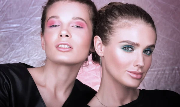 Mode närbild porträtt av två vackra unga kvinnor. Ljusa professionell makeup — Stockfoto