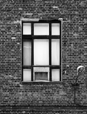 Eski bir tuğla bina cephesinde pencere. Çatı katı tarzında mimari parça