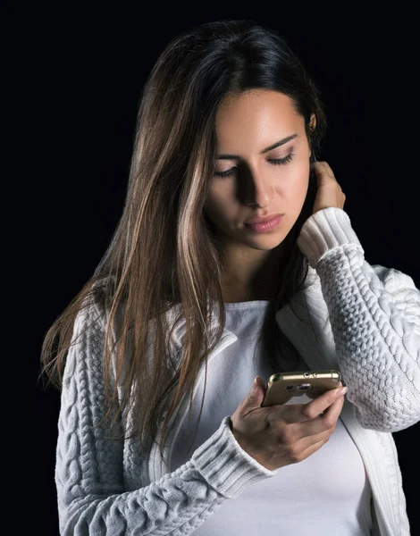 Sad news, vertical portrait. Young woman with phone in hand reading a message