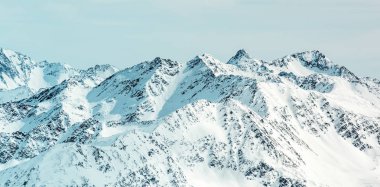 Yüksek Alp panorama. Karla kaplı tepeler ve bulutlu gökyüzü
