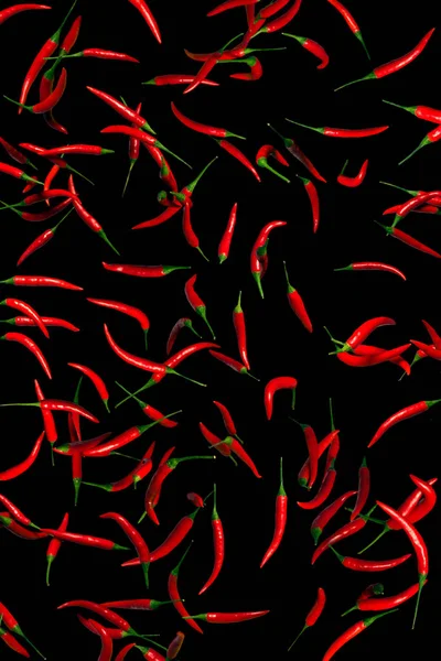 Jede Menge rote Paprika auf schwarzem Hintergrund. Konzeptionelle Collage — Stockfoto