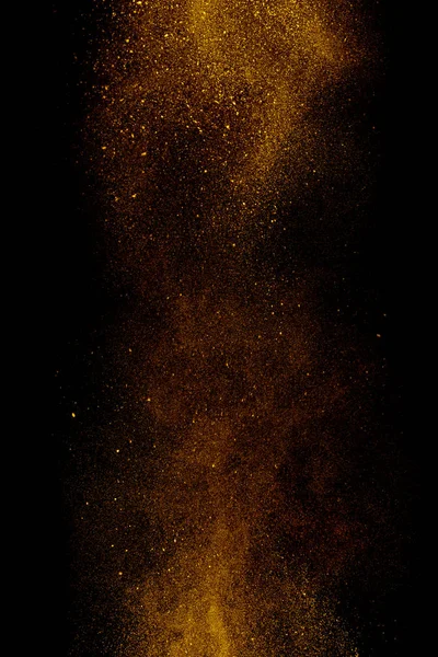 Gold dust on a black background. Fine particles in motion