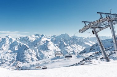 Telesiyej Alpine Kayak merkezinde. Destek ve boş koltuklar. Karla kaplı dağ zirveleri