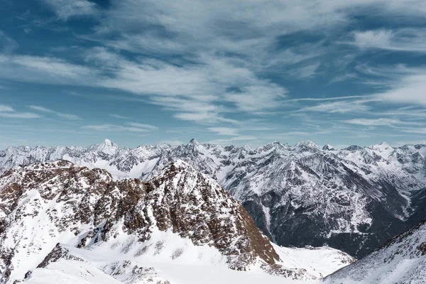 Alpine panoramic Alpine landscape. Mountain peaks in the snow on a background