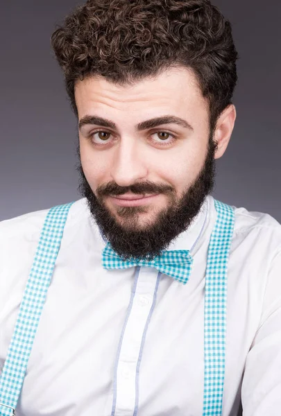 Gizemli bir gülümseme ile genç bir adam portresi. Şık beyaz gömlek, kravat ve askı