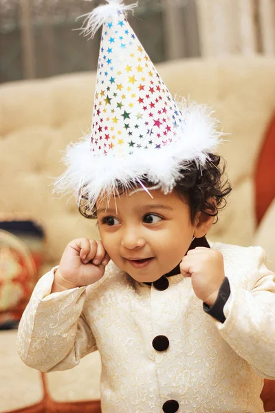 Menino feliz usando chapéu de aniversário e celebrando seu aniversário . — Fotografia de Stock