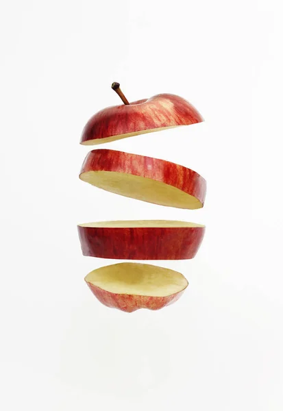 Fresh red golden delicious apple cut into slices floating — Stock Photo, Image