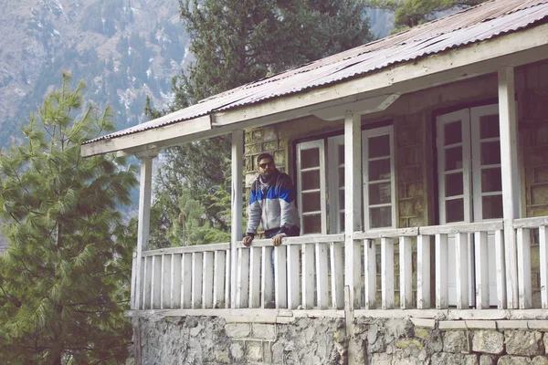 Guy debout sur la terrasse d'un chalet en montagne — Photo