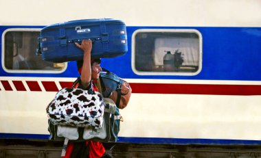 Karaçi Cantt istasyonunda bir sürü çanta taşıyan işçi