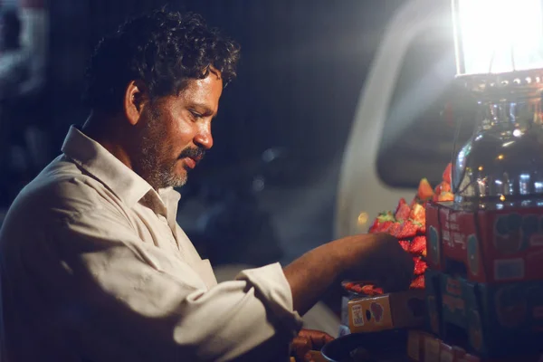 Человек, продающий клубнику на дороге в Бахадурабаде — стоковое фото
