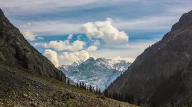 Mohodand Lake Swat, Pakistan 'da güneşli bir günde buzul ve dağların tepesinde bulutlar hareket ediyor - 4K Timelapse