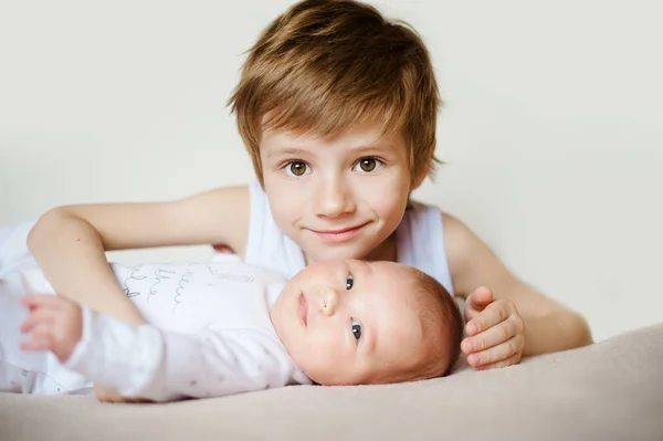 Portrait of cute happy siblings. young boy holding his infant baby — Stock Photo, Image