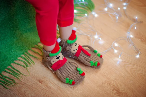 Legs in socks near Christmas garland — Stock Photo, Image