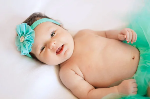 Bébé fille enfant couché sur couverture blanche souriant heureux rose mode portrait visage studio shot caucasien — Photo