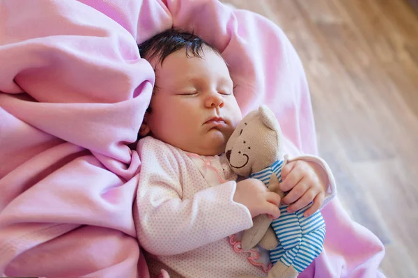 Bonito bebê recém-nascido dorme com um ursinho de pelúcia de brinquedo — Fotografia de Stock