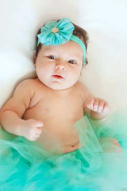 iki aylık bebek etek ve yay saçında giyen yalan