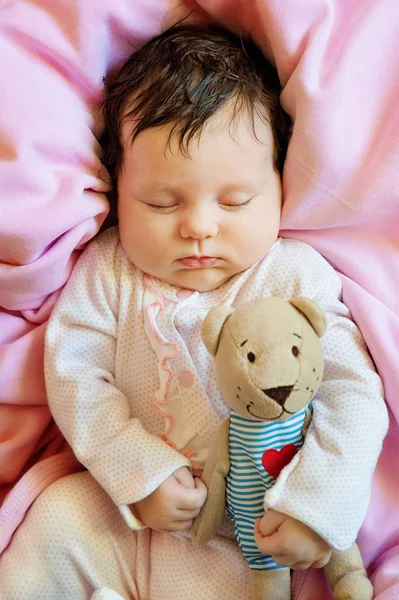 Bonito bebê recém-nascido dorme com um ursinho de pelúcia de brinquedo — Fotografia de Stock