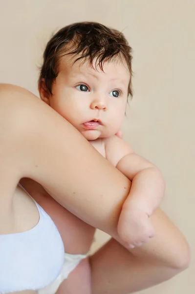 Adorável bebê segurando mães apertadas pescoço e ombro . — Fotografia de Stock