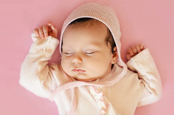 Mooie pasgeboren babymeisje met roze hoed en blauwe ogen closeup — Stockfoto