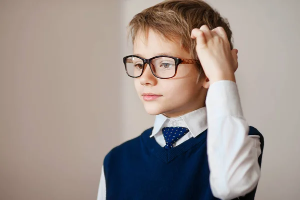 Pensando en el retrato infantil de un niño de siete años en gafas profundamente sobre algo que busca espacio de copia por encima de su cabeza — Foto de Stock