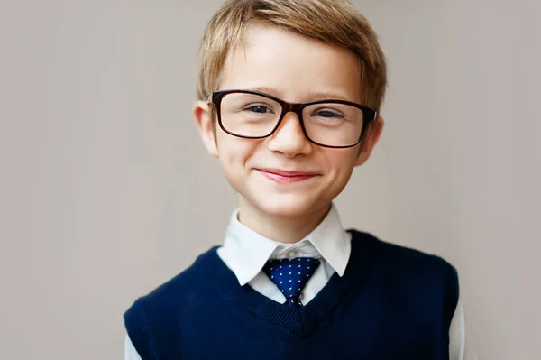 Fechamento do rapazinho de uniforme escolar. Menino feliz sorrindo e olhando para a câmera . — Fotografia de Stock