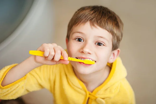 Niño pequeño en albornoz amarillo con cepillo de dientes — Foto de Stock