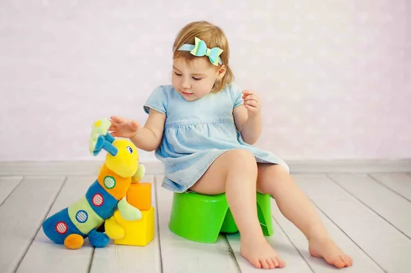 Evinde bir oyuncakla sevimli küçük kız oturak trainting — Stok fotoğraf