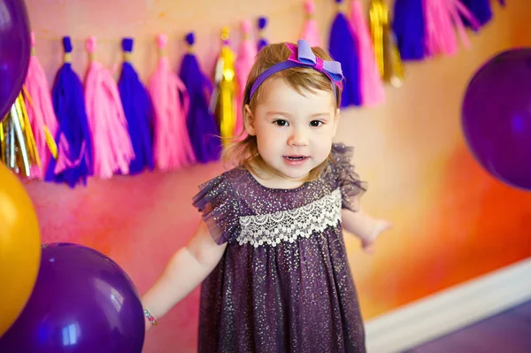 Petite fille mignonne avec décor de fête sur fond de mur coloré — Photo