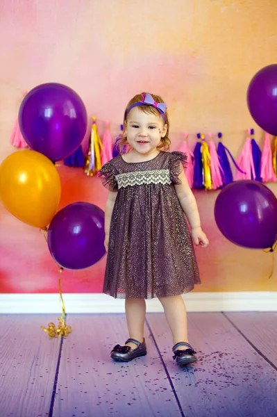 Un portrait d'une belle petite fille rit dans un studio décoré de nombreux ballons de couleur — Photo