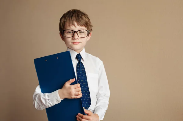 Şık takım elbise ve bir Tablet kağıt Chesterfield kanepede oturan gözlük akıllı çocuk. Eğitim kavramı. Çocuk moda. Vintage tarzı. Kopya alanı.