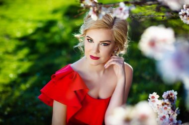 Şu yeni gelişen ağaç bahar bahçe yakınındaki poz bir stil ile güzel genç kadın uzun saçlı toplandı. Parfüm reklam kavramı.