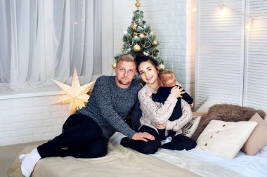 Genç aile anne baba küçük bebek evlat oturup Noel ağacı, mutlu tatil yeni yıl hediye, el feneri, mucize bekliyorum. modern iç mekan, yaşam duygular değil, modelleri
